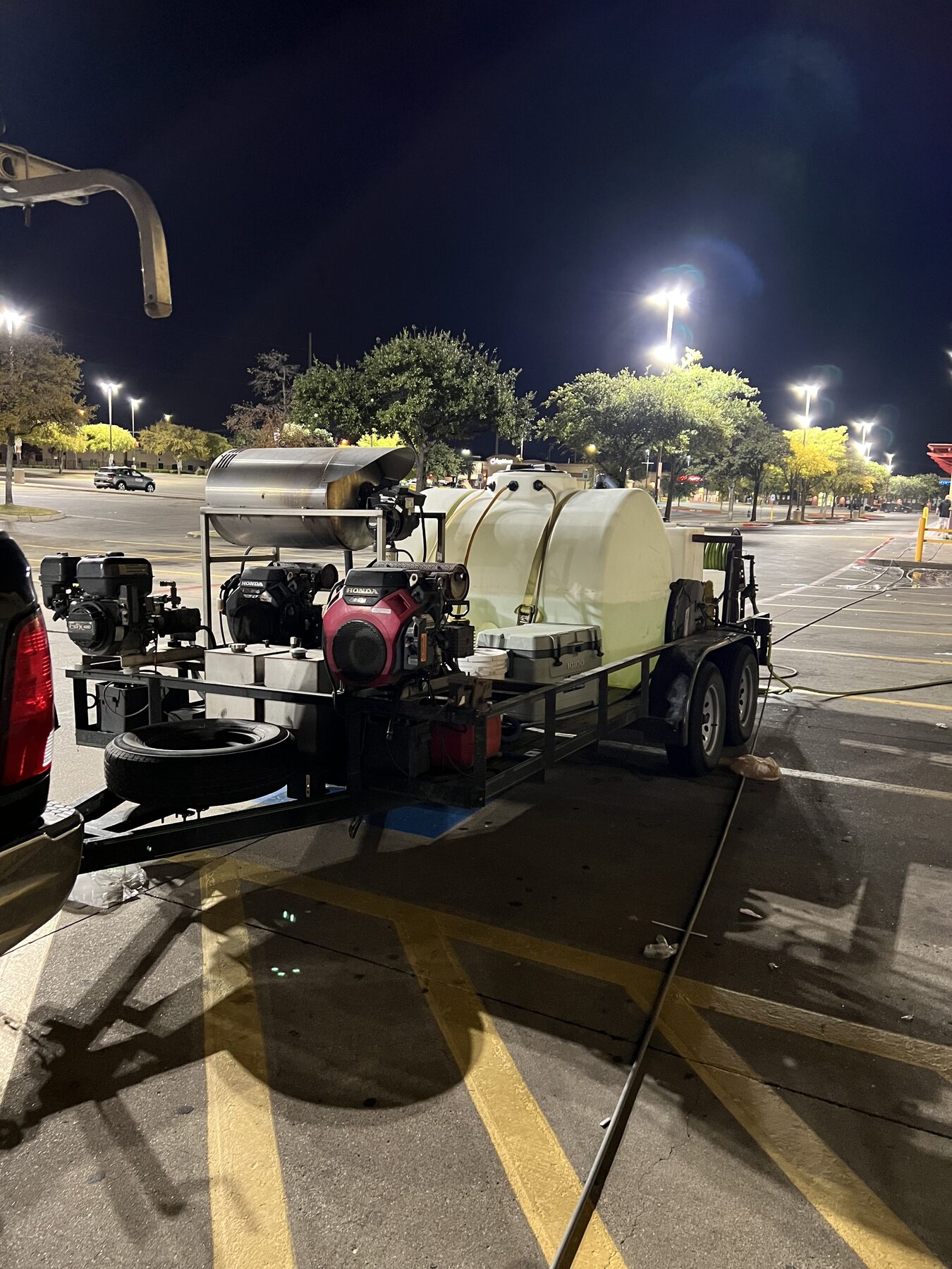 Hot-water commercial rig staged on a retail lot at night